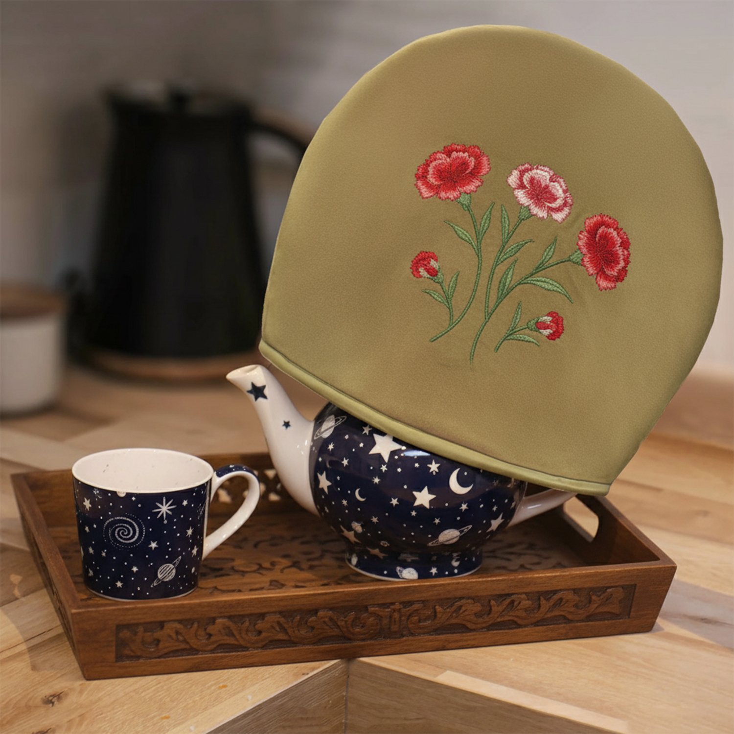 Teapot with floral cozy and starry cup on wooden tray in cozy kitchen setting.