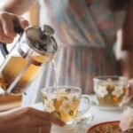Brew Tea with French Press: Easy Guide to Making Perfect Tea Pouring tea from French press into floral cups, served with cookies and flowers on a sunny kitchen table.