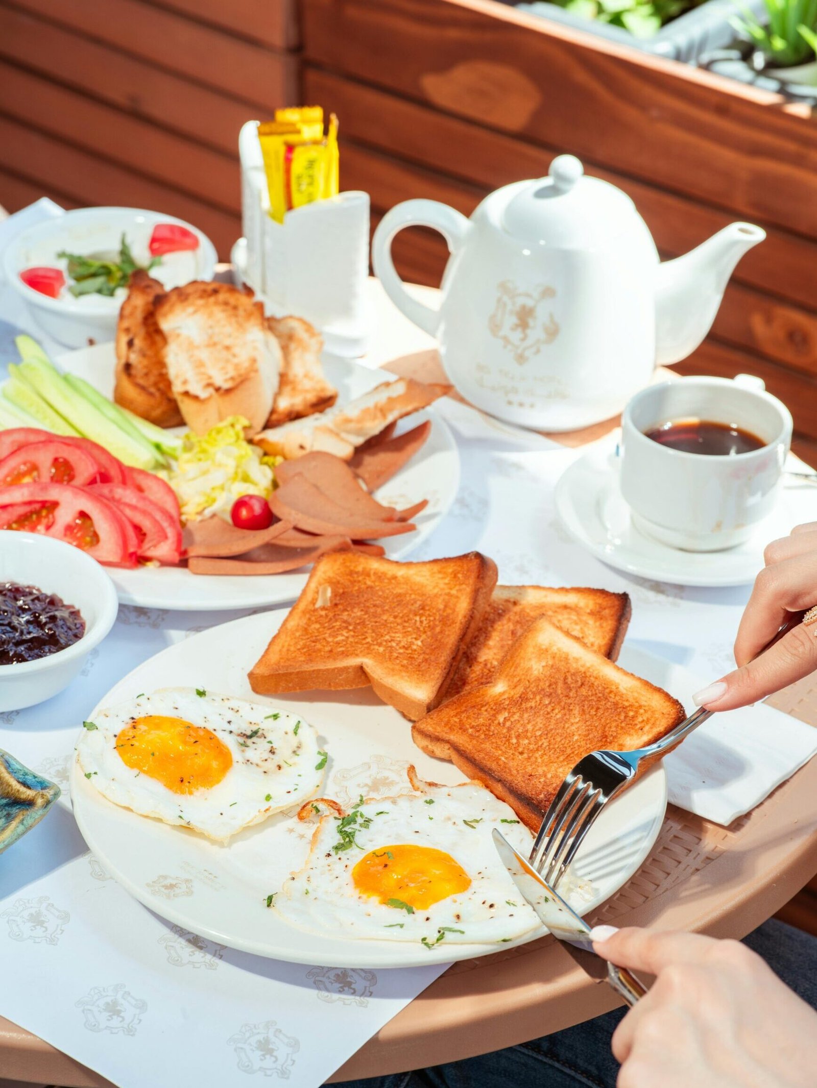 Delicious breakfast with sunny-side-up eggs, toast, salad, and tea, perfect for a nutritious start to the day.