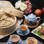 Chinese cuisine spread featuring dumplings, roast duck, tea set, and dessert on a black reflective surface.